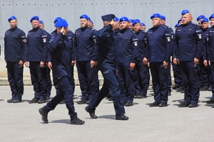 policjanci stoją w szeregach, przed nimi przechodzi Zastępca Komendanta Głównego Policji