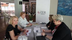 cztery kobiety siedzą przy stole, w tle logo ZER MSWiA