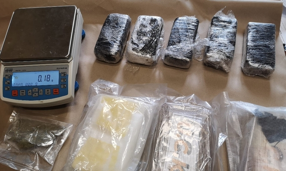 zabezpieczone narkotyki w foliowych pakunkach i waga elektroniczna
