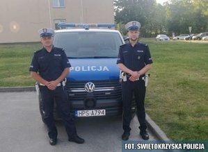 umundurowani policjanci stoją przy radiowozie