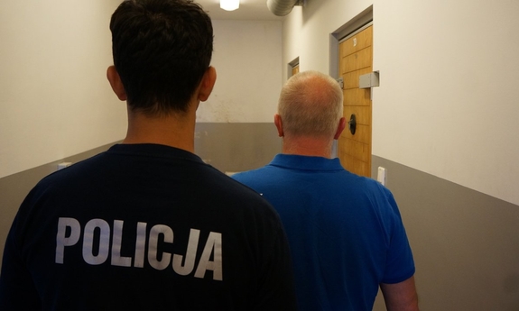 policjant prowadzi zatrzymanego mężczyznę