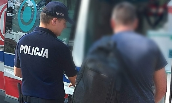 policjant pomaga wejść do karetki mężczyźnie