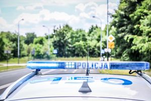 dach radiowozu policyjnego, na którym znajduje się sygnalizator świetlny z napisem policja