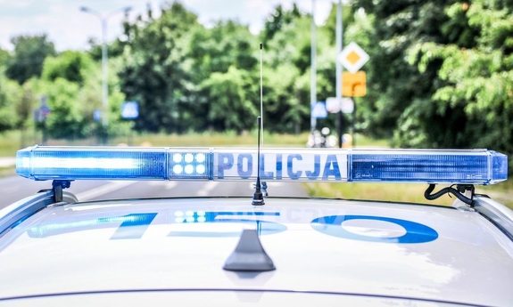 dach radiowozu policyjnego, na którym znajduje się sygnalizator świetlny z napisem policja