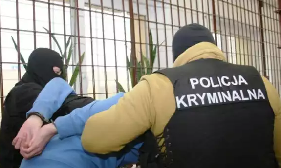 dwaj policjanci prowadza mężczyznę zakutego w kajdanki