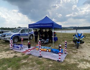 Miasteczko ruchu drogowego w tle namiot profilaktyczny z policjantami.