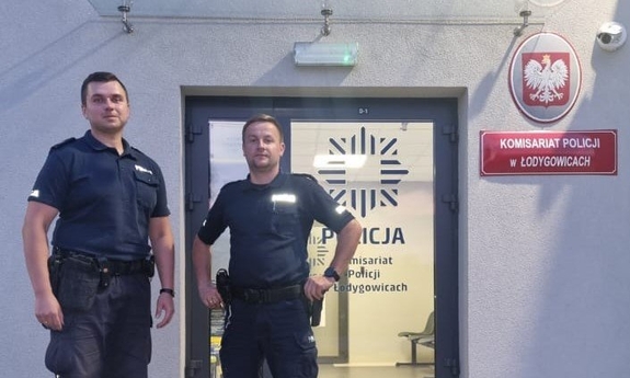 policjanci stoją obok siebie na tle budynku komisariatu