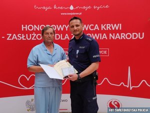 odznaczony policjant z mężczyzną, trzyma dyplom i legitymację
