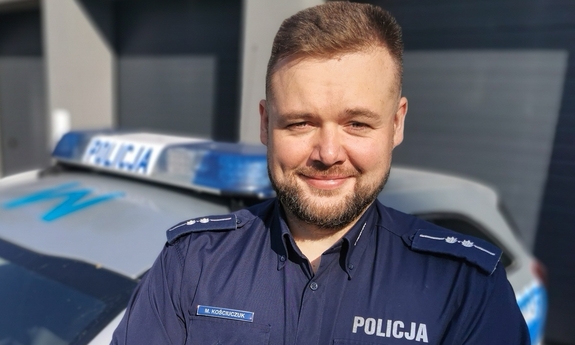 umundurowany policjant, w tle radiowóz