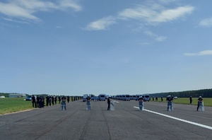 policjanci z oddziałów prewencji i policyjne radiowozy podczas ćwiczeń na pasie lotniska