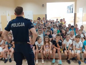 Policjant rozmawia z grupą uczniów.