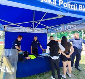 Policjanci z uczestnikami wydarzenia w namiocie profilaktycznym.