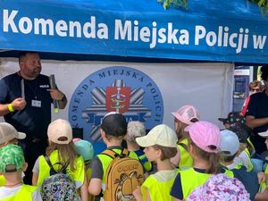 Policjant z dziećmi w namiocie profilaktycznym.
