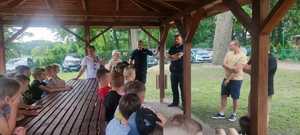 Policjanci rozmawiają z dziećmi i ich opiekunami.