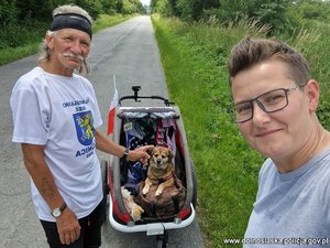 mężczyzna z psem w wózku i kobieta - policjantka w czasie wolnym pozują do selfie, które robi kobieta