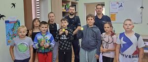 Policjanci pozują do zdjęcia z grupą dzieci.