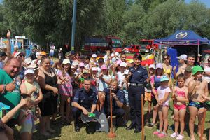 Policjanci pozują do zdjęcia z uczestnikami pikniku.