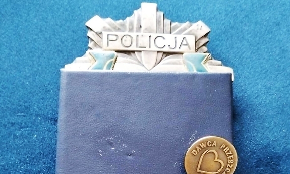 legitymacja dawcy przeszczepu i odznaka dawcy przeszczepu leżą na legitymacji policyjnej