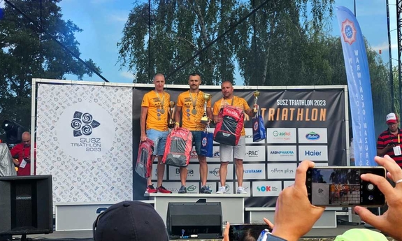 Na zdjęciu podium ustawione na scenie. Na środku stoi policjant z Jasła wraz z pucharem i medalem. Po jego obu bokach zawodnik z drugiego i trzeciego miejsca