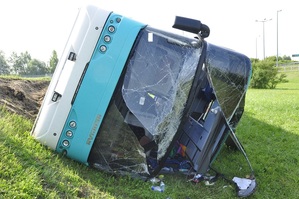 uszkodzony autobus leżący w przydrożnym rowie