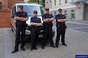 umundurowani policjanci stoją przy radiowozie