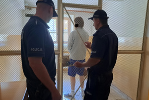 dwaj policjanci z zatrzymanym mężczyzną