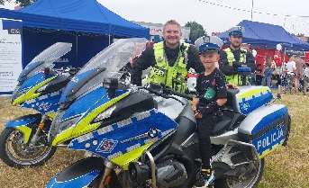 Chłopiec siedzący na motocyklu policyjnym