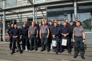 Grupa polskich i litewskich policjantów pozuje do zdjęcia stojąc na schodach wejściowych do budynku.