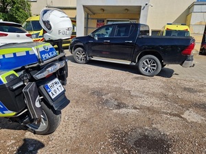 samochód i motocykl policyjny przed budynkiem szpitala