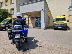 motocykl policyjny i karetka pogotowia przed budynkiem szpitala