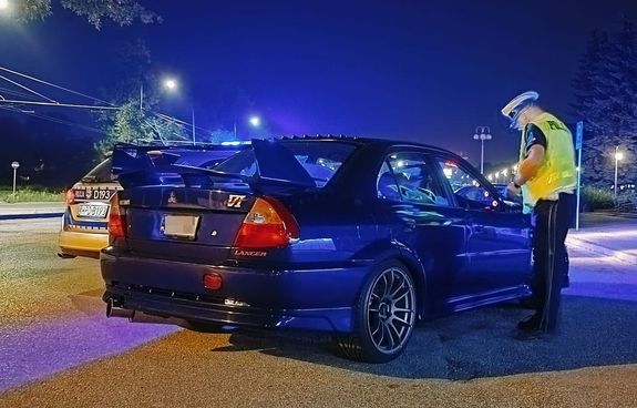 Pora nocna. Policjant ruchu drogowego kontroluje samochód