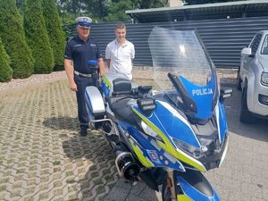 uczeń klasy mundurowej stoi z policjantem przy motocyklu policyjnym