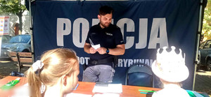 Policjant z dziećmi w namiocie profilaktycznym.