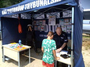 Policjant z dzieckiem w namiocie profilaktycznym.