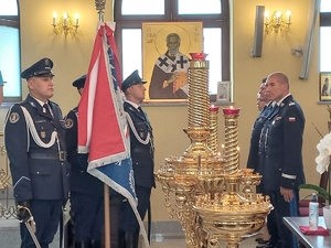 policjanci w ławkach podczas nabożeństwa, naprzeciwko nich poczet sztandarowy