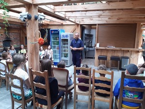 Policjant rozmawia z grupą dzieci.