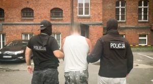 Dwaj policjanci prowadzą zatrzymanego