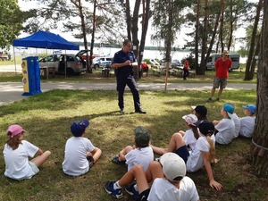 Policjant rozmawia z grupą dzieci.