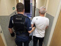 policjant prowadzi zatrzymanego