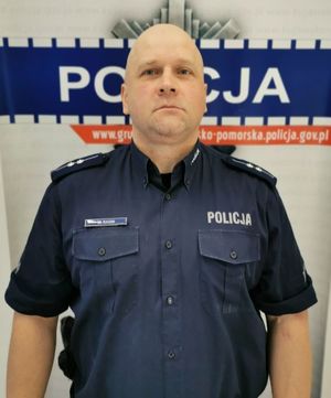 umundurowany dzielnicowy, z tyłu widoczny napis: Policja