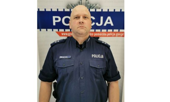 umundurowany dzielnicowy, z tyłu widoczny napis: Policja