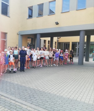 Policjantka pozuje do zdjęcia z grupą dzieci wypoczywających na obozie.