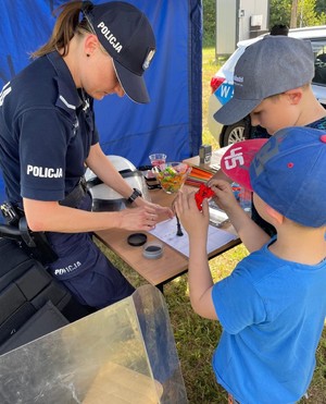 Policjantka z dziećmi w namiocie profilaktycznym.