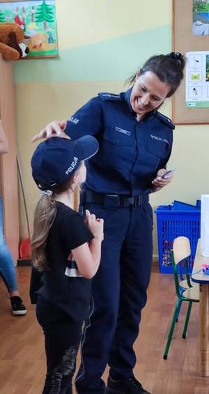 Policjantka z dzieckiem przebranym w strój policjanta.