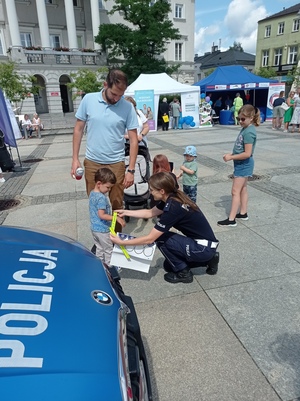 Policjantka z uczestnikami pikniku.