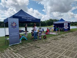 Namiot profilaktyczny Policji obok uczestnicy pikniku.
