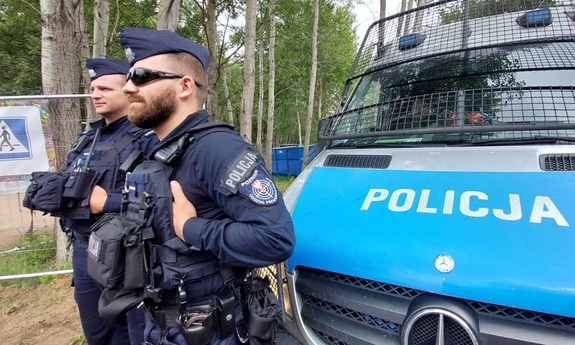 dwaj policjanci stoją przy radiowozie policyjnym