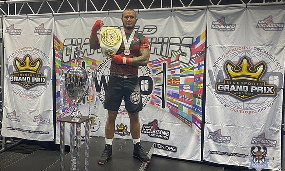 Sierżant Konrad Piechaczek z pasem mistrzowskim na podium