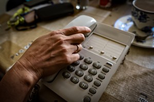 Dłoń podnosząca słuchawkę na telefonie