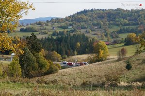 widok z oddali na stojące na drodze radiowozy policyjne i pojazd nielegalnych imigrantów